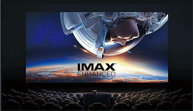 Imagem de dentro de um cinema com a tela mostrando os dizeres IMAX Enhanced